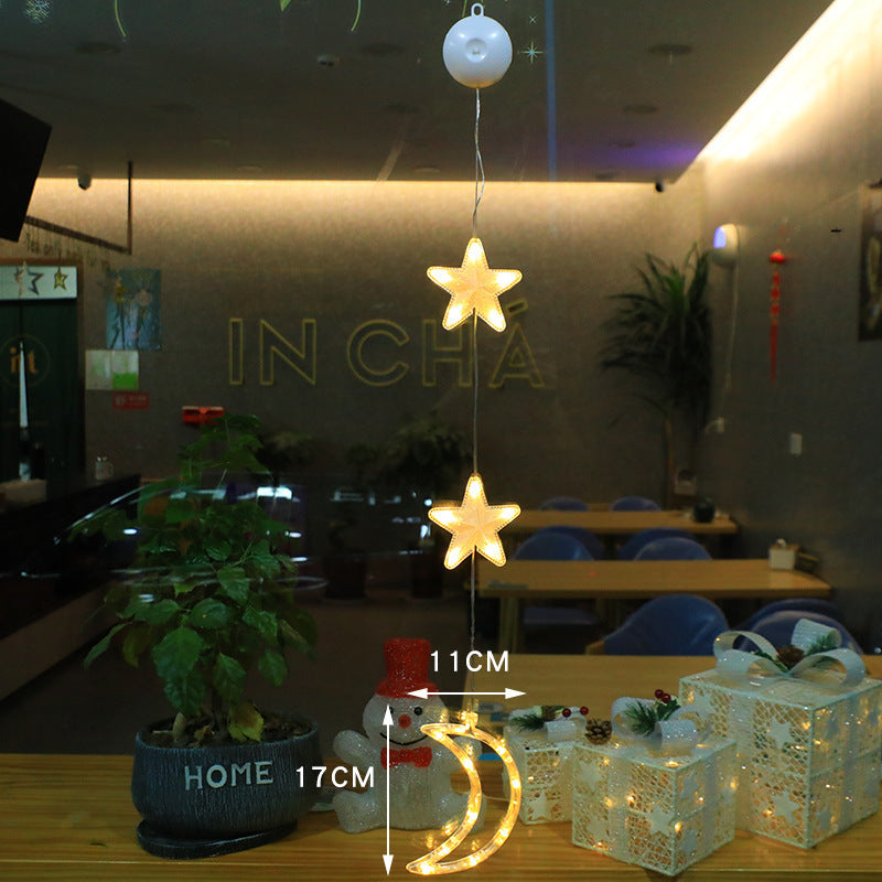 Tre lysande julhängen med sugpropp i fönster